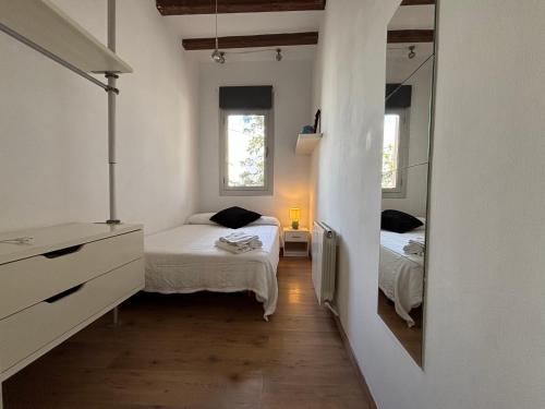 a small bedroom with two beds and a mirror at MODERN FLAT POBLE NOU in Barcelona