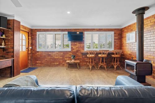 a living room with a couch and a stove at Sea Breeze on Gibbon - Walk to the Beach and the Bowlo in Lennox Head