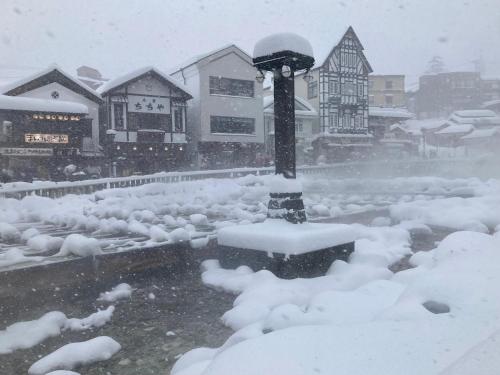 a street light covered in snow in a city at Hotel Sakurai in Kusatsu