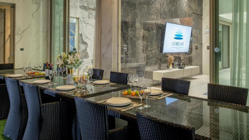 HHQにあるA Dream Hua Hin - Beachfront Retreatの椅子付きの長いテーブルと壁に掛けられたテレビ