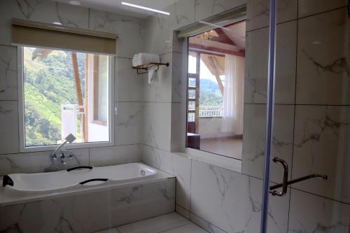 a white bathroom with a sink and a mirror at The TeaTree Munnar in Suryanelli