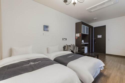 a hotel room with two beds and a table at Incheon Aiport Airrelax hotel in Incheon