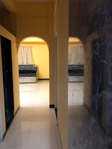 an empty hallway with two windows in a room at Down Town Home Stay in Alibaug