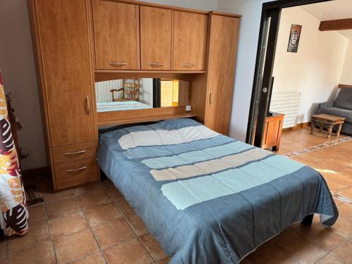 une chambre avec un lit et une armoire en bois dans l'établissement T2 Climatise sur le BASSIN D ARCACHON, à Gujan-Mestras