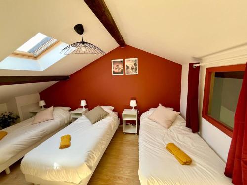 due letti in una stanza con pareti rosse di BnGo I Maison Mimosa I Jardin, 3 chambres, 9 personnes a Villeurbanne