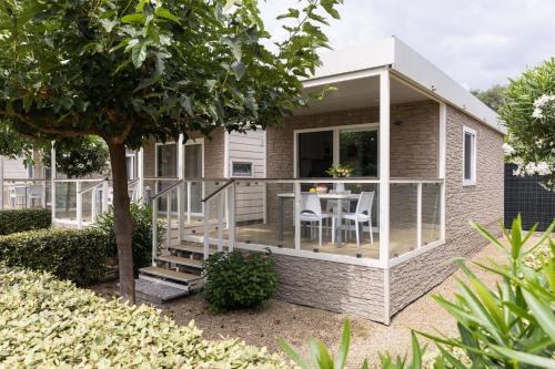 a house with a wrap around deck with a table at ReBi Village in Imperia