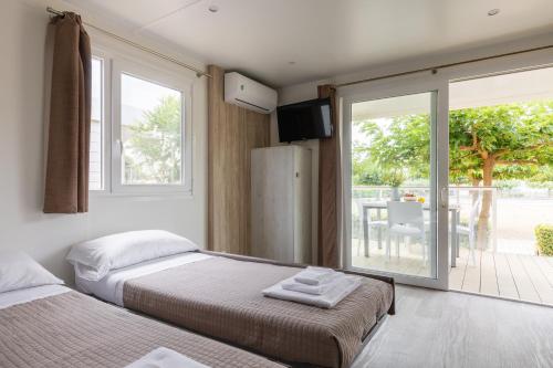 a bedroom with two beds and a sliding glass door at ReBi Village in Imperia