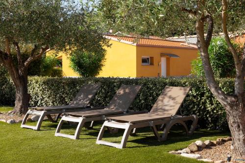 two lounge chairs sitting on the grass in a yard at ReBi Village in Imperia