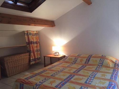 une chambre avec un lit et une lampe sur une table dans l'établissement Maison 3 pièces - Gruissan Ayguades AY060-070, à Vires