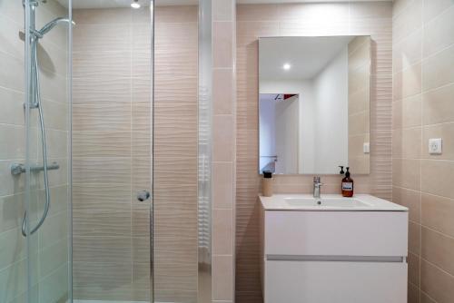 une salle de bain avec une douche, un lavabo et un miroir dans l'établissement Le Blue Dock - Port de Vannes, à Vannes