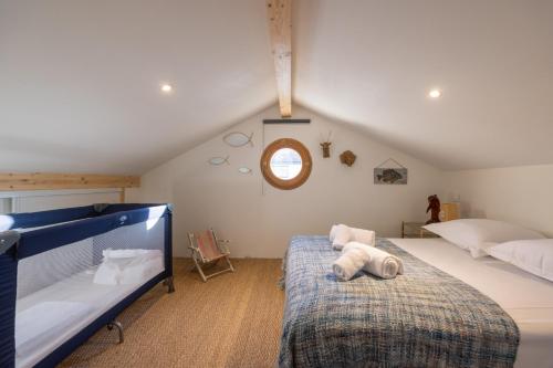 - une chambre mansardée avec 2 lits et une fenêtre dans l'établissement L'Espérance - Belle terrasse proche de la plage, à Gujan-Mestras