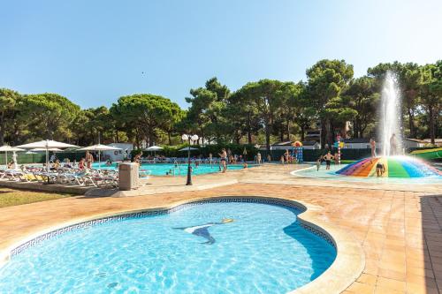 a swimming pool with a fountain in a park at Camping Alannia Neptuno in Pals