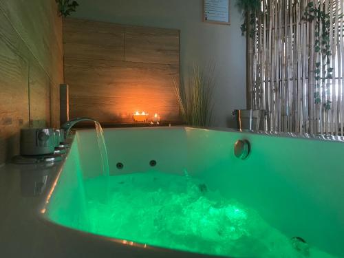 a green tub with a faucet in a bathroom at La Love - Love room Marseille in Marseille