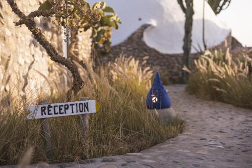 a street sign in the grass next to a building at DAV MAHAL Eco lodge in Sidi Kaouki