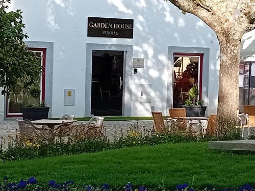 a building with a table and chairs in a yard at Garden House Fundão in Fundão