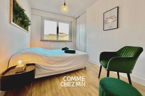 a bedroom with a bed and a green chair at Appartement Nancy Thermal 6 personnes avec Garage in Nancy