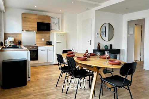 a kitchen and dining room with a wooden table and chairs at Appartement Nancy Thermal 6 personnes avec Garage in Nancy