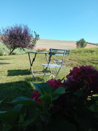 a picnic table and a chair in the grass at Les balcons du cap in Escalles
