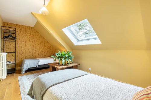 a attic bedroom with two beds and a skylight at Les logis de Kergoulou in Concarneau