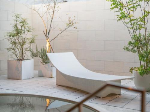 a white couch in a room with potted plants at FIVE SPRING RESORT THE SHIRAHAMA in Shirahama