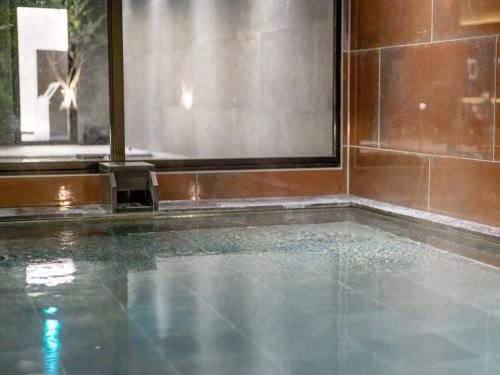 a swimming pool in a room with a window at FIVE SPRING RESORT THE SHIRAHAMA in Shirahama