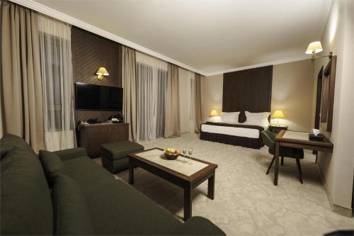a hotel room with a couch and a bed at Maxi Park Hotel & Spa in Velingrad