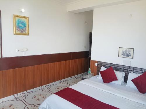 a hotel room with a bed with red pillows at Hotel D Pal in Kandāghāt