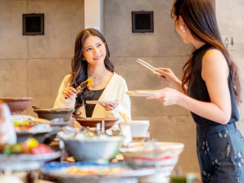 two women standing in a kitchen preparing food at FIVE SPRING RESORT THE SHIRAHAMA in Shirahama