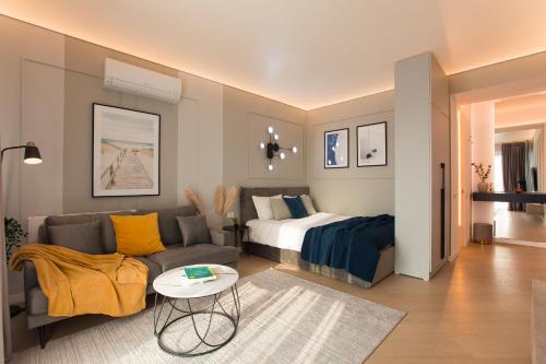 un salon avec un canapé et un lit dans l'établissement Cortina North - Modern Studio Apartment with Balcony, à Voluntari