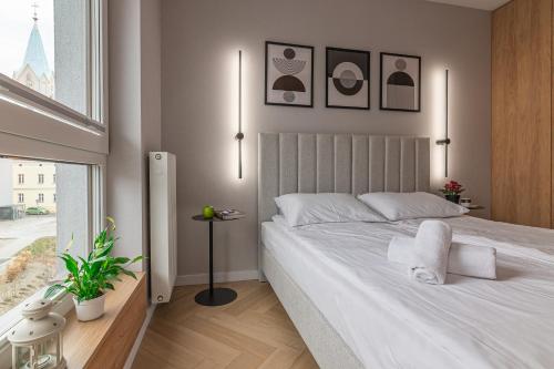 a bedroom with a large white bed and a window at River Side Residence in Oświęcim