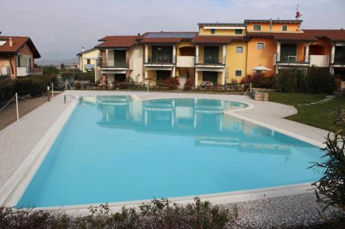 a large blue swimming pool in front of some houses at New Home Lazise in Lazise
