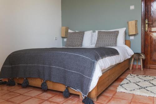 a bedroom with a bed with a gray blanket on it at DAV MAHAL Eco lodge in Sidi Kaouki