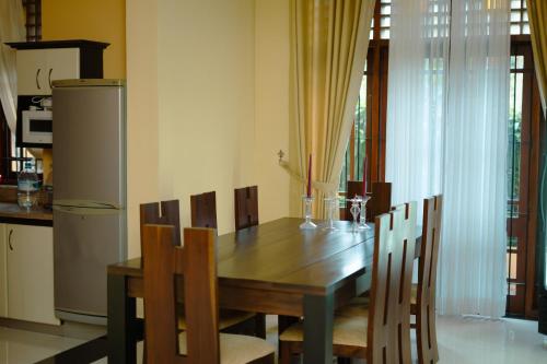 a dining room table with chairs and a refrigerator at Bigcity Villa - Airport Transit Hotel in Katunayake