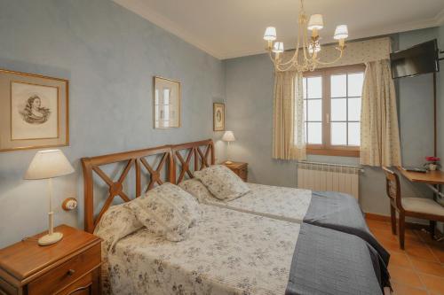 a bedroom with a bed and a table and a window at La Panera in Castrojimeno