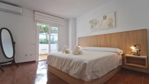 ein Schlafzimmer mit einem großen Bett und einem Spiegel in der Unterkunft SeaHomes Vacations - Villa Chill & Pool 200m Beach in Pineda de Mar