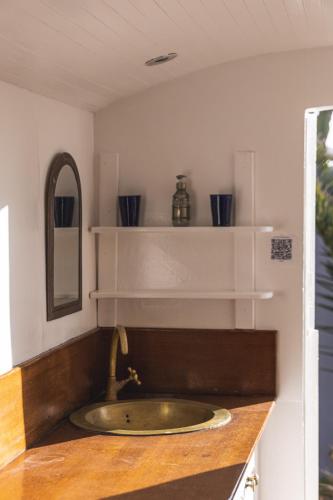 a sink in a bathroom with shelves on the wall at DAV MAHAL Eco lodge in Sidi Kaouki