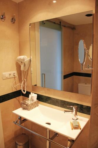 a bathroom with a sink and a large mirror at Hotel Playas de Torrevieja in Torrevieja
