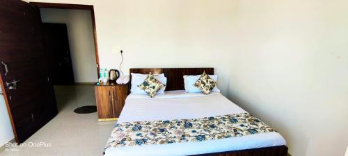 a bedroom with a bed with a white bedspread and pillows at Vedas Homestay by Mandothiya's in Rīngas