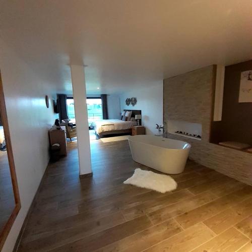 une grande salle de bain avec baignoire et une chambre dans l'établissement Emille et une nuits, à Mérignies