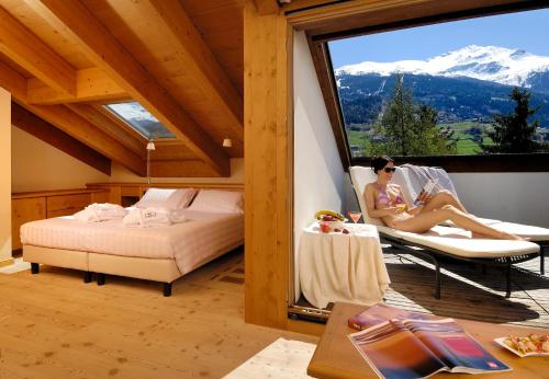 a woman sitting in a chair in a room with a window at Miramonti Park Hotel in Bormio
