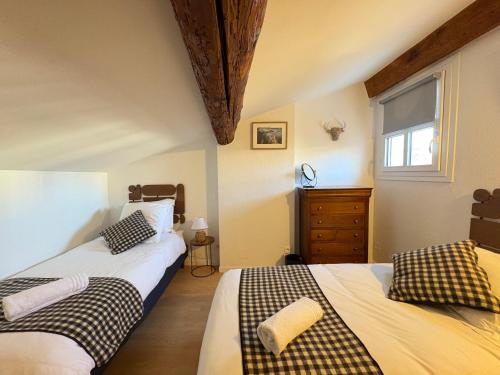 une chambre avec deux lits et une fenêtre dans l'établissement La maison de Gaston*Arles*Arènes, à Arles