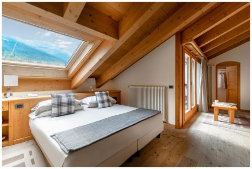 a bedroom with a bed and a large window at Miramonti Park Hotel in Bormio