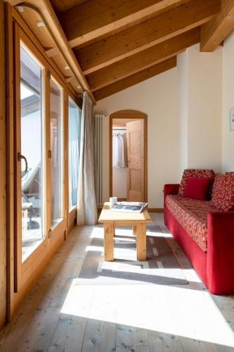 a living room with a red couch and a table at Miramonti Park Hotel in Bormio