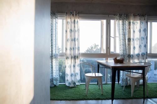 a table and two chairs in a room with a window at The Acanti, Dharamshala in Dharamshala