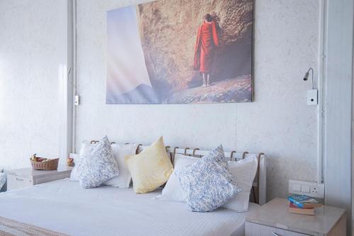 a bedroom with a bed with blue and white pillows at The Acanti, Dharamshala in Dharamshala