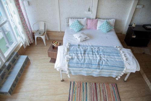 a bedroom with a bed with a blanket on it at The Acanti, Dharamshala in Dharamshala