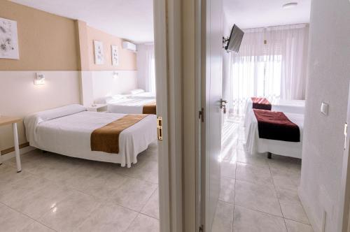 a hotel room with two beds and a bathroom at Hostal Gran Vía in Pinto