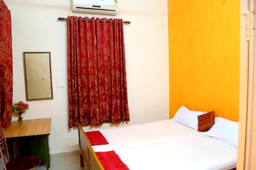 Cette chambre comprend 2 lits et un rideau rouge. dans l'établissement Fort Garden Residency, à Cochin