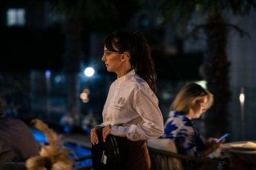 a woman standing in front of a crowd of people at Avenue Hotel in Ksamil