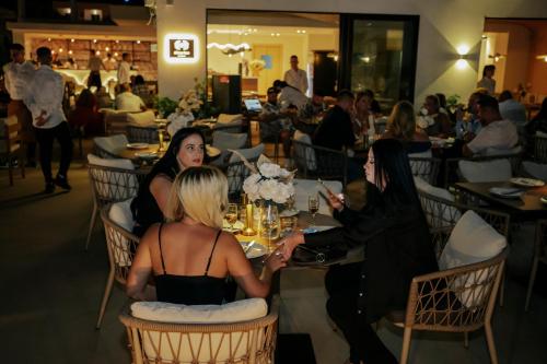 a group of women sitting at a table in a restaurant at Avenue Hotel in Ksamil
